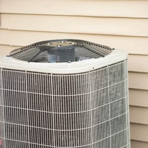 Outdoor residential air conditioning unit beside house siding for home cooling efficiency
