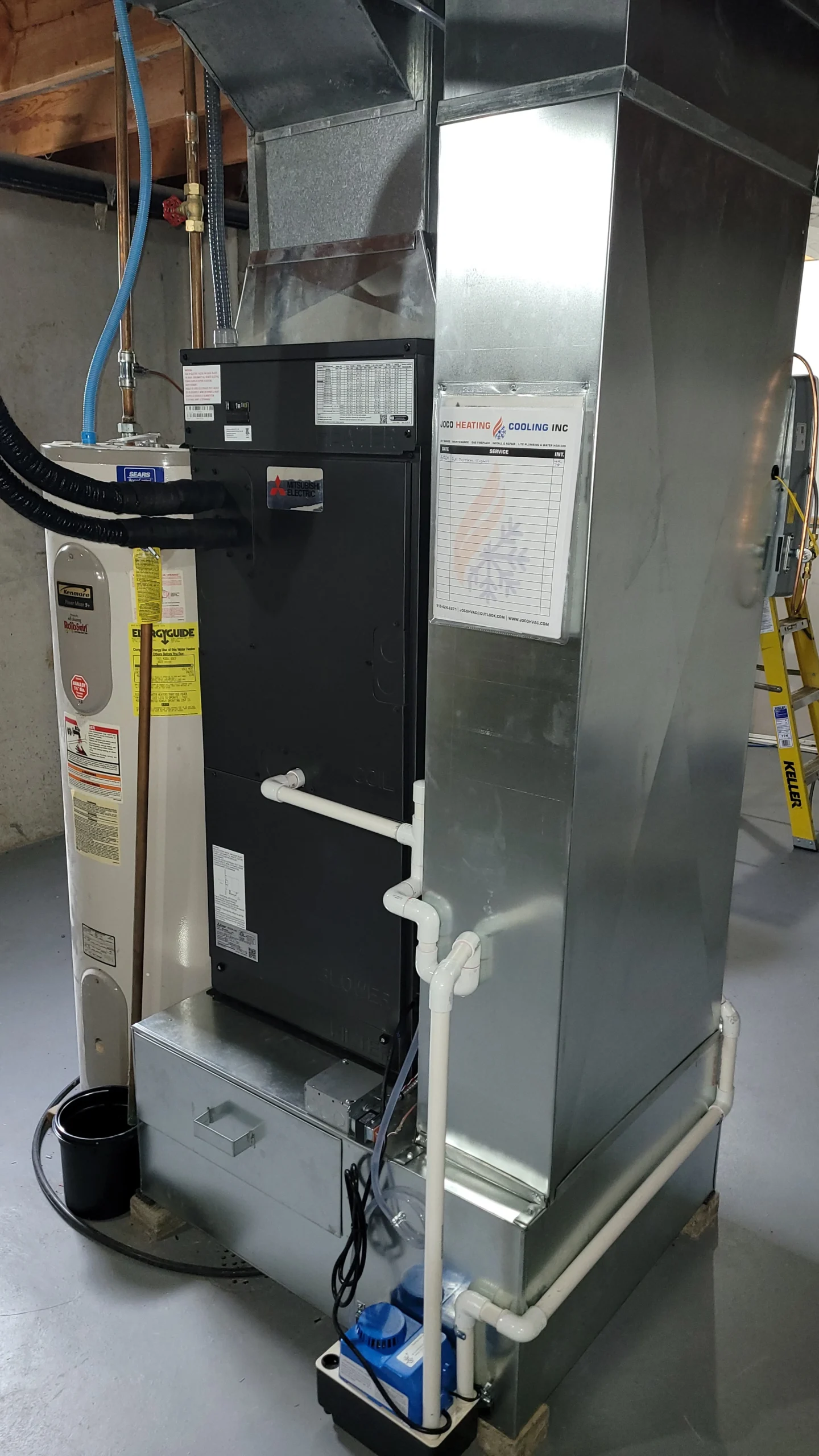 Metal air handler and furnace unit connected to ductwork and piping in a residential basement utility area