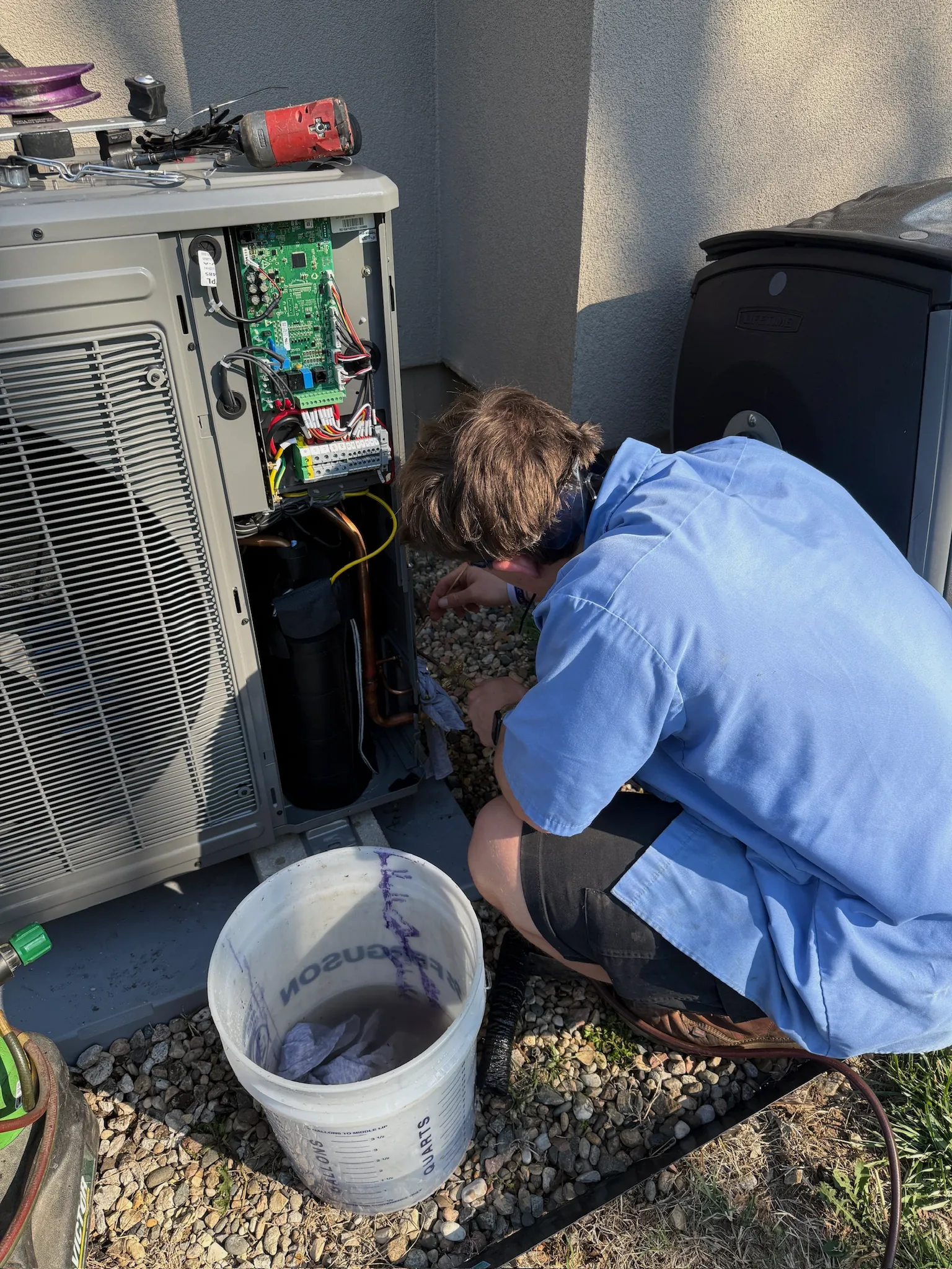 JOCO HVAC technician repairing an AC condenser circuit board and compressor components
